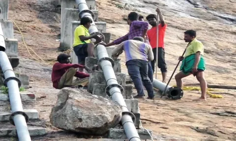 உடைந்த குடிநீர் குழாயை சீரமைக்கும் பணியில் ஈடுபட்டுள்ள கோவில் ஊழியர்கள்.