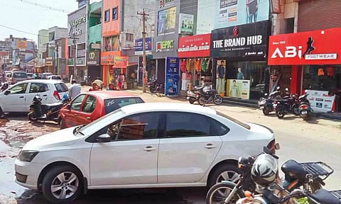 சாலையை ஆக்கிரமித்து நிறுத்தப்பட்டிருந்த வாகனங்களை படத்தில் காணலாம்.