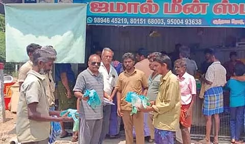 டவுனில் உள்ள மீன் கடையில் சுகாதார அலுவலர் இளங்கோ பிளாஸ்டிக் பைகளை பறிமுதல் செய்த காட்சி.