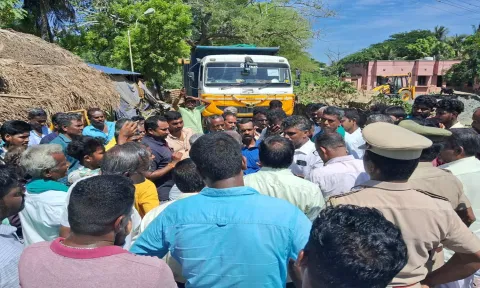 லாரியை சிறைபிடித்து வாக்குவாதத்தில் ஈடுபட்ட கிராம மக்கள்.
