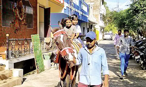 மாணவர்களை பள்ளிக்கு குதிரையில் அழைத்து வந்த தந்தை.