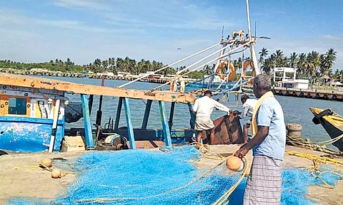 மீன்பிடி துறைமுகத்தில் விசைப்படகுகளில் தளவாட பொருட்களை ஏற்றும் மீனவர்கள்.