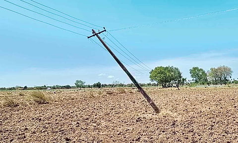 சாய்ந்த நிலையில் தாழ்வாக செல்லும் மின்கம்பிகள்.