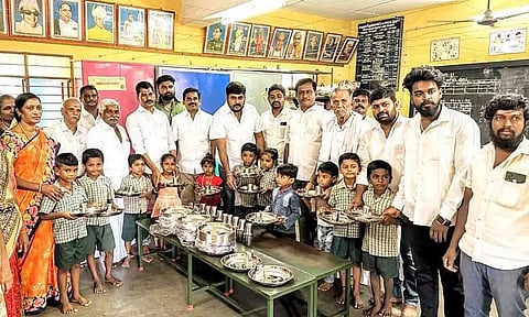 பள்ளி குழந்தைகளுக்கு  சாப்பிடும் தட்டு, டம்ளர்கள் வழங்கப்பட்ட காட்சி.