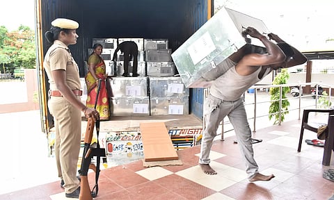 பெங்களூரில் இருந்து வந்த மின்னணு வாக்குப்பதிவு எந்திரங்களை ஈரோடு ஆர்.டி.ஓ. அலுவலகத்தில் உள்ள மின்னணு வாக்குப்பதிவு எந்திரக்கிடங்கில் துப்பாக்கி ஏந்திய போலீஸ் பாதுகாப்புடன் இறக்கி வைக்கப்பட்ட போது எடுத்த படம்.