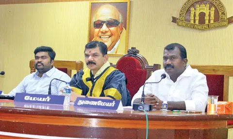 மாநகராட்சி கூட்டத்தில் மேயர் சரவணன் பேசிய காட்சி. அருகில் துணை மேயர்  கே.ஆர்.ராஜூ, மாநகராட்சி கமிஷனர் சிவகிருஷ்ணமூர்த்தி உள்ளனர்.