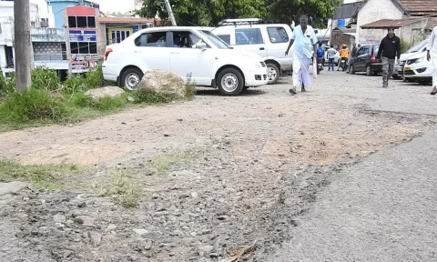 நெரிசல் மிகுந்த பார்க்கிங்கில் சேதமடைந்துள்ள சாலை.
