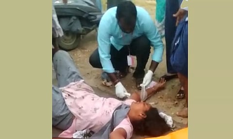 காயம் அடைந்த ஆசிரியை ஜோதிக்கு 108 ஆம்புலன்ஸ் ஊழியர் சிகிச்சை அளித்த காட்சி.