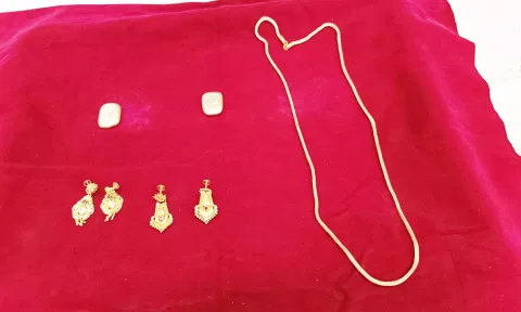 திருட்டு வழக்கில் கைப்பற்றப்பட்ட தங்க நகைகள். கைது செய்யப்பட்ட  நிரஞ்சன் மற்றும் நிதிஷ்குமாரை படத்தில் காணலாம்.