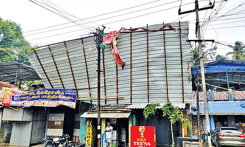 வீட்டின் மேற்கூரை பறந்து மின்சார கம்பத்தில் சிக்கியது.