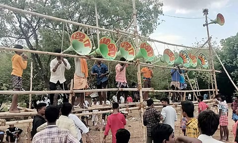 உசிலம்பட்டி அருகே நடைபெற்ற இசைப்போட்டியை முன்னிட்டு கூம்பு வடிவ ஒலிபெருக்கிகள் கட்டப்பட்டுள்ள காட்சி.&nbsp;