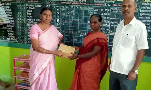 பள்ளித் தலைமை ஆசிரியர்&nbsp; நூலகப் பொறுப்பாசிரியரிடம் புத்தகம் வழங்கிய காட்சி.&nbsp; &nbsp;