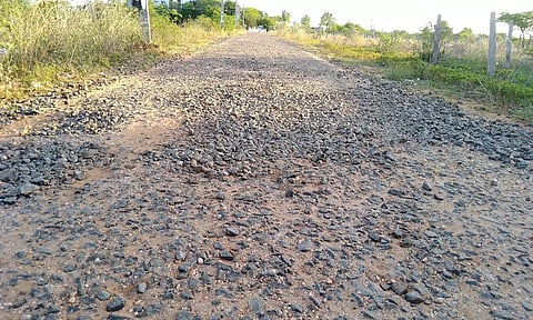குண்டும் குழியுமாக காணப்படும் சாலை.