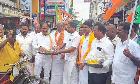 காந்திவீதி-நேரு வீதி  சந்திப்பில் பொதுமக்களுக்கு பா.ஜனதா மாநில தலைவர் சாமிநாதன் இனிப்பு வழங்கிய காட்சி.