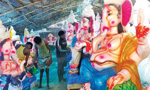 விநாயகர் சிலைகளுக்கு வர்ணம் பூசும் பணியில் ஈடுபட்டுள்ள தொழிலாளர்கள்.
