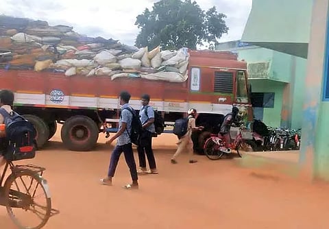 அரசு பள்ளி முன்பு நிறுத்தப்பட்டிருக்கும் கழிவு லாரி.