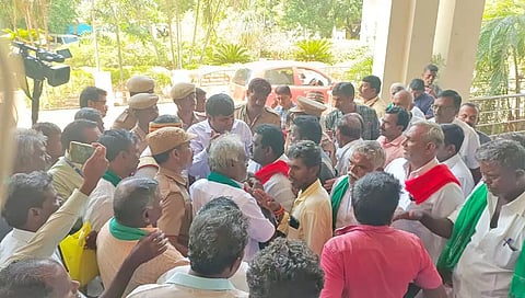 தர்ணா போராட்டத்தில் ஈடுபட்ட விவசாயிகளுடன் கலெக்டர் கார்த்திகேயன் பேச்சுவார்த்தை நடத்திய காட்சி.