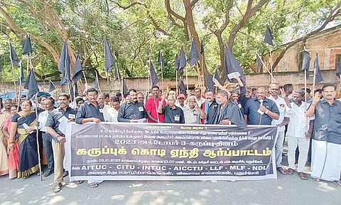 தொழிற்சங்கத்தினர் கருப்புக்கொடியுடன் ஆர்ப்பாட்டம் செய்த காட்சி.