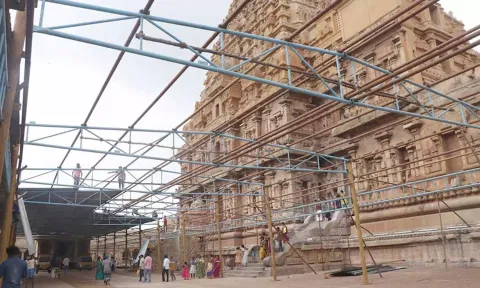 பந்தல் அமைக்கும் பணியில் ஈடுபட்டுள்ள தொழிலாளர்கள்.
