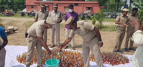 போலீசார் மதுப்பாட்டில்களை அழித்த காட்சி