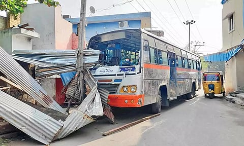 மின் கம்பத்தில் மோதி நிற்கும் தனியார் பஸ்.