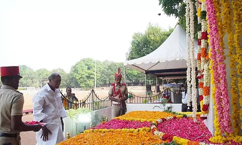 இறந்த போலீசாரின் நினைவு தூணுக்கு முதல்-அமைச்சர் ரங்கசாமி மலர் அஞ்சலி செலுத்திய காட்சி.