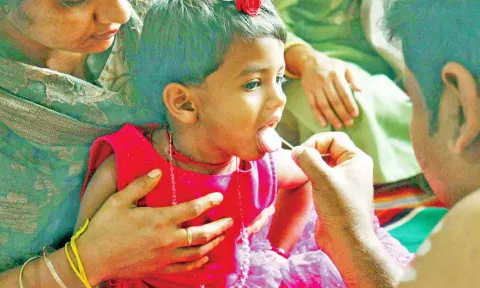 அய்யப்பன் கோவிலில் வித்யாரம்பம் நிகழ்ச்சி ஒரு குழந்தைக்கு அர்ச்சகர் தங்க வேலால் நாக்கில் எழுதி காட்சி.