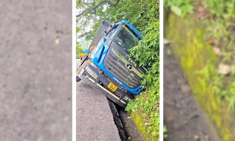 கனரக லாரி கவிழ்ந்து  நிற்பதை படத்தில் காணலாம்.