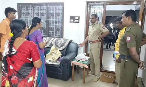 கொள்ளை நடந்த வீட்டில் போலீசார் விசாரணை மேற்கொண்ட காட்சி.
