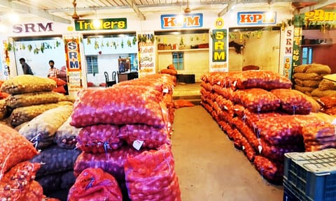 பாவூர்சத்திரம் மார்க்கெட்டில் குவித்து வைக்கப்பட்டுள்ள சின்னவெங்காய மூட்டைகள்.