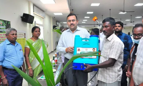 தென்காசி மாவட்ட கலெக்டர் ரவிச்சந்திரன் விவசாயி ஒருவருக்கு மின்கல மருந்து தெளிப்பான் எந்திரம் வழங்கிய காட்சி.