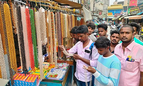 துளசி மாலைகளை தேர்ந்தெடுத்து வாங்கும் பக்தர்கள்.