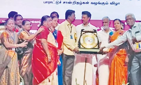 அமைச்சர் அன்பில் மகேஷ் பொய்யாமொழியிடம்  தலைமையாசிரியர் பாலமுருகன் பரிசை பெற்றார்.