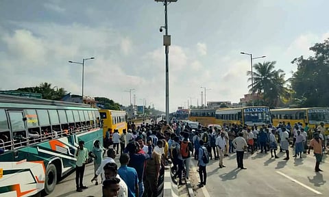 சாலை மறியல் காரணமாக கல்லூரி-பள்ளி வாகனங்கள் அணிவகுத்து நின்ற காட்சி.