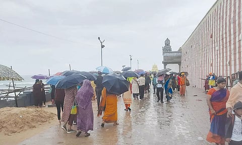 சுற்றுலா பயணிகளும், ஐயப்ப பக்தர்களும் குடைபிடித்தபடி சுற்றுலா தலங்களை சுற்றி பார்ப்பதை படத்தில் காணலாம்.