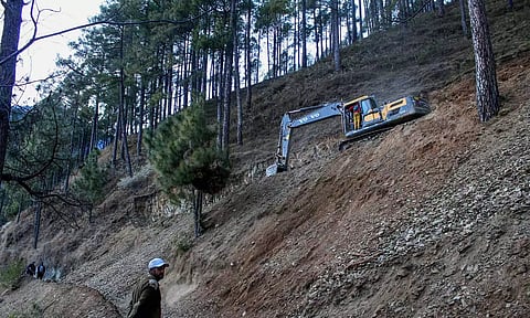 மலையில் சாலை அமைக்கும் பணி நடந்து வருவதை காணலாம்.