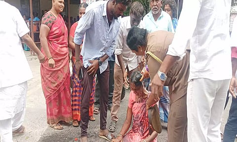 தீக்குளிக்க முயன்ற பெண்ணை போலீசார் தடுத்து நிறுத்திய காட்சி.