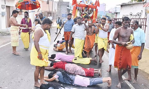 பண்ணாரியம்மன் கோவில் சப்பரம் முன்பு தரையில் படுத்து வழிபட்ட பள்ளி மாணவிகள்