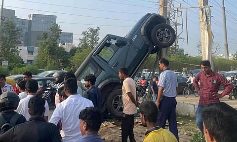 மின்கம்பத்தில் ஏறிய கார் - வைரலாகும் புகைப்படம்