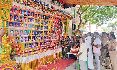 தீ விபத்தில் பலியான குழந்தைகளின் உருவப்படங்களுடன் வைக்கப்பட்டிருந்த பேனருக்கு பெற்றோர்கள் மலர் தூவி அஞ்சலி செலுத்திய காட்சி.