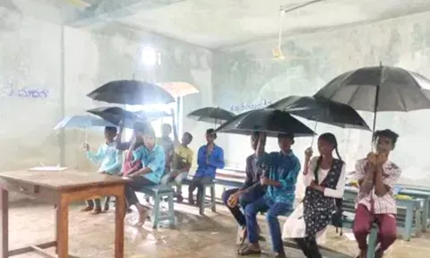 வகுப்பறையில் நீர்கசிவு: குடை பிடித்த படி அமர்ந்து பாடம் கவனித்த மாணவர்கள்