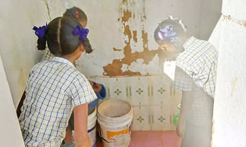 கழிவறையை மாணவிகள் சுத்தம் செய்வது போன்று பரவும் காட்சி.