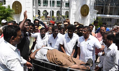 காயமடைந்த வியாபாரியை ஸ்டெச்சரில் வைத்து புதுச்சேரி கவர்னர் மாளிகையை முற்றுகையிட்டு போராட்டம்