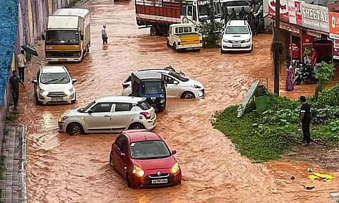 &nbsp;மங்களூரு பம்ப்வெல் சந்திப்பு சாலையில் பெருக்கெடுத்து ஓடிய மழை வெள்ளத்தில் சிக்கிய வாகனங்கள்.