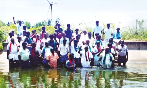 நீர்வளத்துறை அதிகாரிகளை கண்டித்து அமராவதி அணை கால்வாயில் இறங்கி விவசாயிகள் போராட்டம்