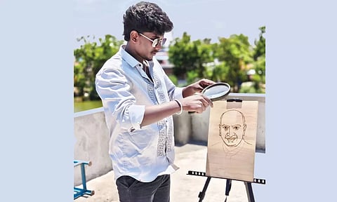 சூரிய ஒளிக்கதிரை பயன்படுத்தி லென்ஸ் மூலம் ஓவியங்கள் வரையும் மாணவர் தருண்குமார்.