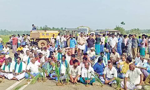 நெற்பயிர்களுடன் விவசாயிகள் சாலையில் அமர்ந்து மறியல் போராட்டத்தில் ஈடுபட்டனர்.