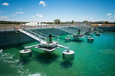 A high-angle view of a modern secondary clarifier and aeration system at a wastewater treatment facility.