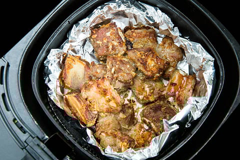 The device functions by circulating the hot air around the food and if you block the airflow with foil, meals may cook unevenly.  