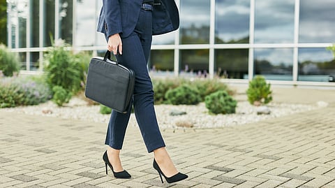 A women carrying her laptop to work.